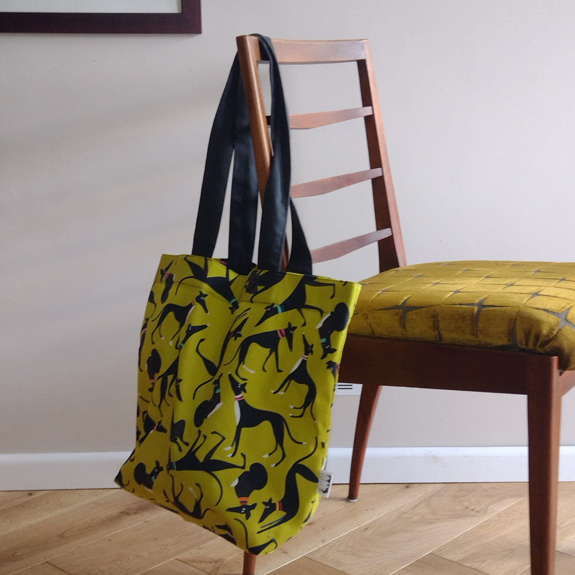Hound Loungers Signature Print Tote bag in Lime green hanging on the back of a chair