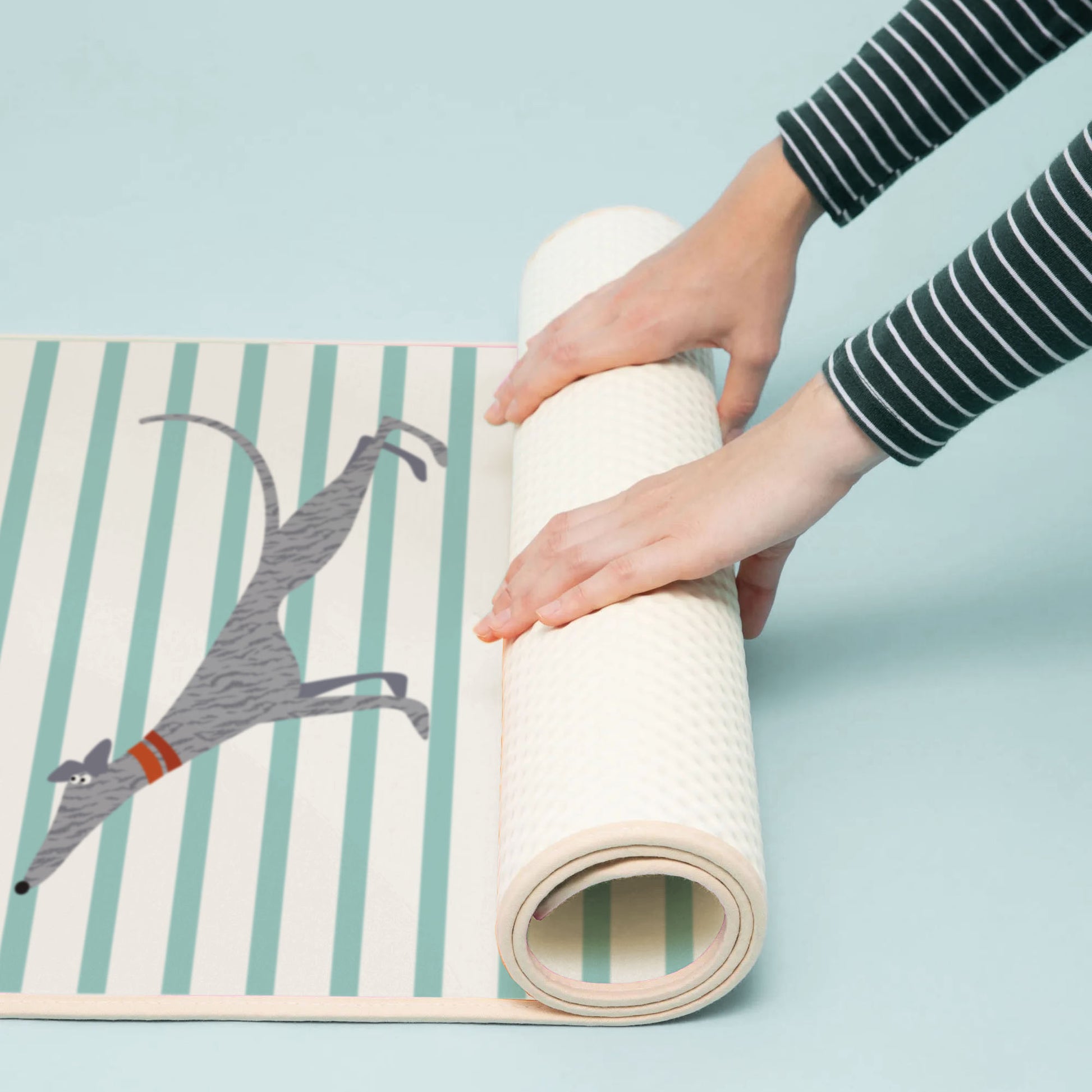 Person unrolling a Hound Yoga Yoga Mat