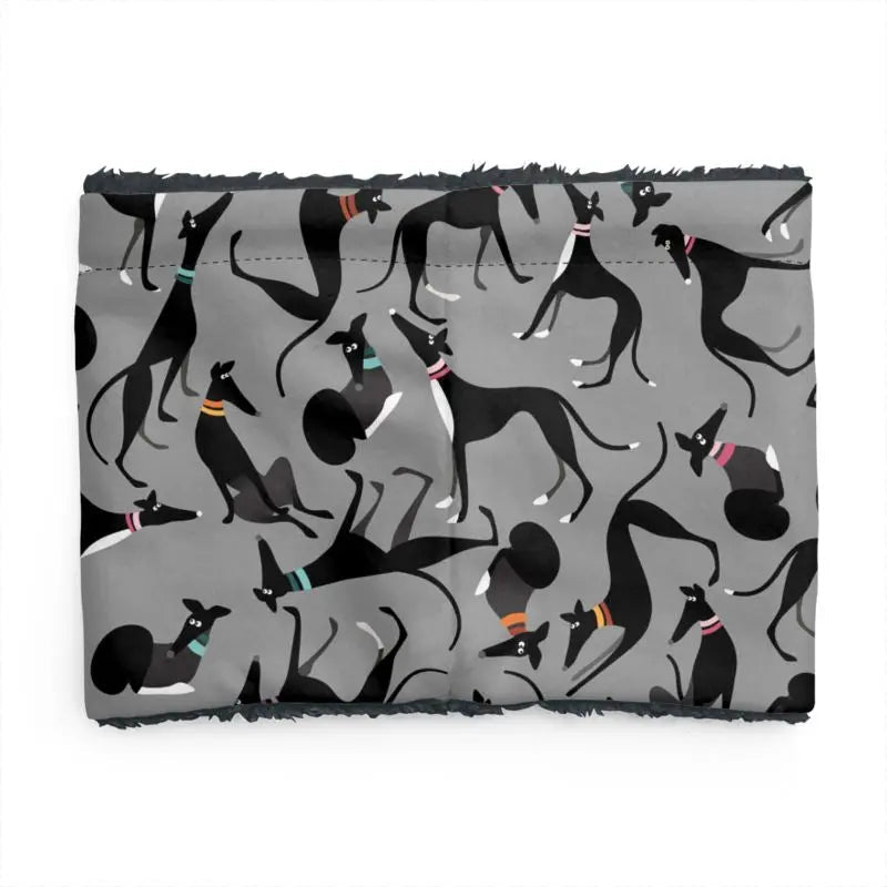 back image of a sherpa fleece lined neck warmer with a grey background. The pattern on the outer is a repeat pattern of cute black and white greyhounds in various poses. The lining is black.