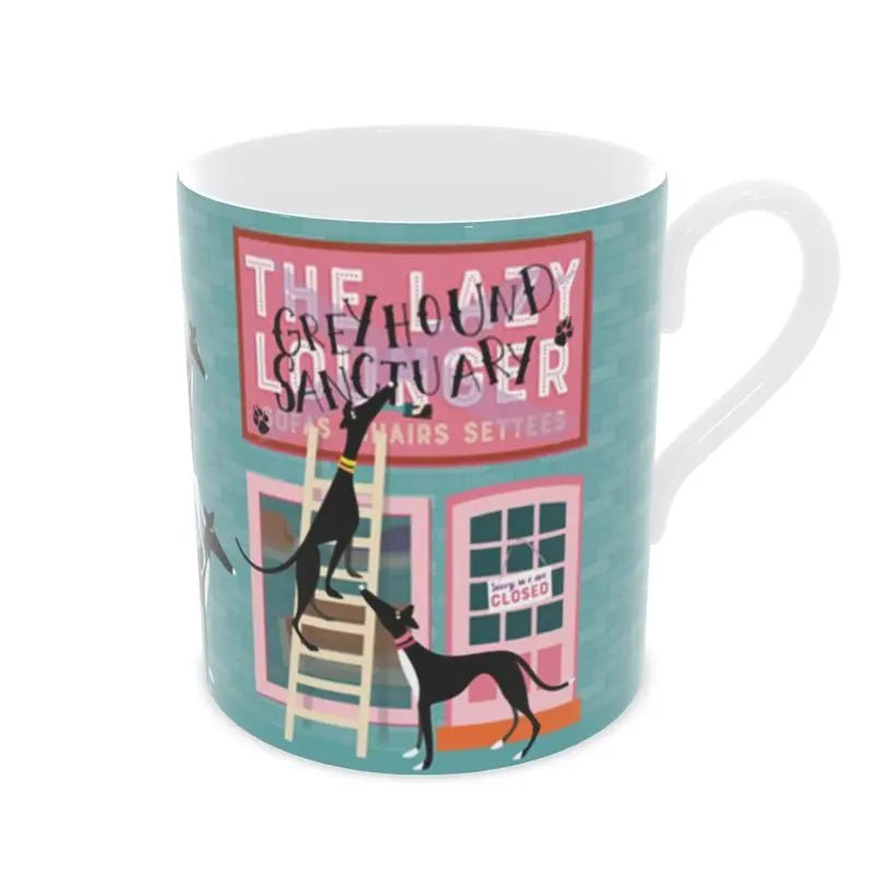 Front view of a bone china mug. The background is turquoise with a brick motif. The image shows the front of a sofa shop called the Lazy Lounger. It is currently closed. There is a greyhound standing up a ladder with a paintbrush in their mouth. They have painted 'Greyhound Sanctury' over the top of the shop sign. There is a 2nd greyhound keeping watch.
