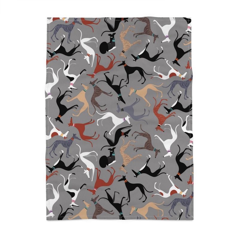 Tea towel with a grey background a featuring a repeat pattern of cute greyhound characters with various coat colours. These hounds are friends of the 2 black & white greyhounds Kushti and Silver who collectively are known as the Hound Loungers.