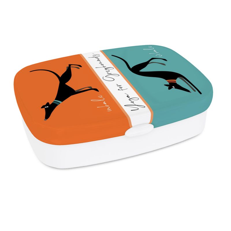 A lunch box white white base. The top has a full colour print. The top section is orange and features a image of a cute black greyhound stretching it's front legs and nose up, it's back legs stretched behind. The text reads 'Inhale'. The lower image is on turquoise and shows a black greyhound with it's front legs and head in a bowed and back legs straight, tail in the air. The text reads exhale. Text in the middle of the box reads 'Yoga for Greyhounds'.
